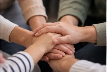 Mani di diversi familiari unite insieme, simbolo di cura e sostegno